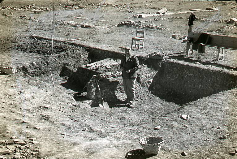 [Vista general d'un sector del jaciment de Clunia amb una persona excavant]