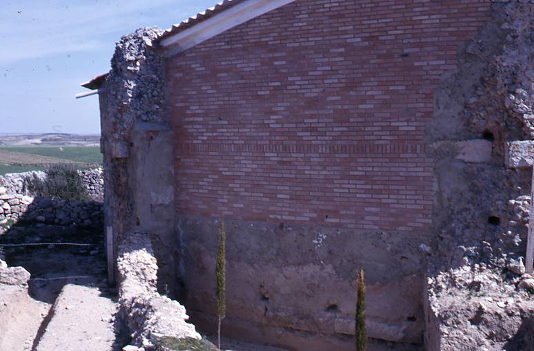 [Mur reparat amb maons moderns de l'edifici en elevació de Clunia]