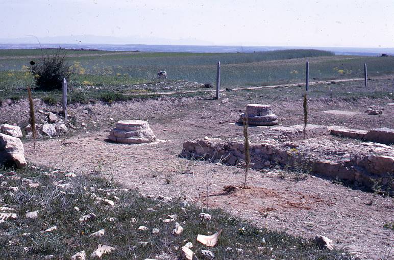 [Vista d'un sector amb base de columna en primer terme del jaciment romà de Clunia]