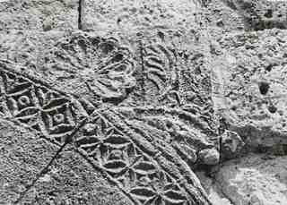 [Restes d'element ornamental reaprofitat a la dreta de l'arc de la portxada del temple de San Juan de Baños]