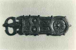 [Placa de cinturó liriforme de bronze amb sivella i agulla, anvers, provinent del jaciment d'El Bovalar]