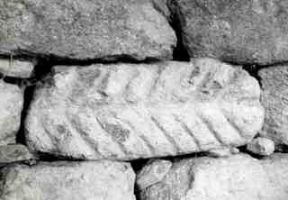 [Carreu reaprofitat a l'església de Santa María de Lugo, amb decoració representant un forma d'espiga]