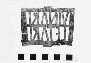 [Aplic decoratiu metàl·lic, calat amb una inscripció, provinent de Saldaña]
